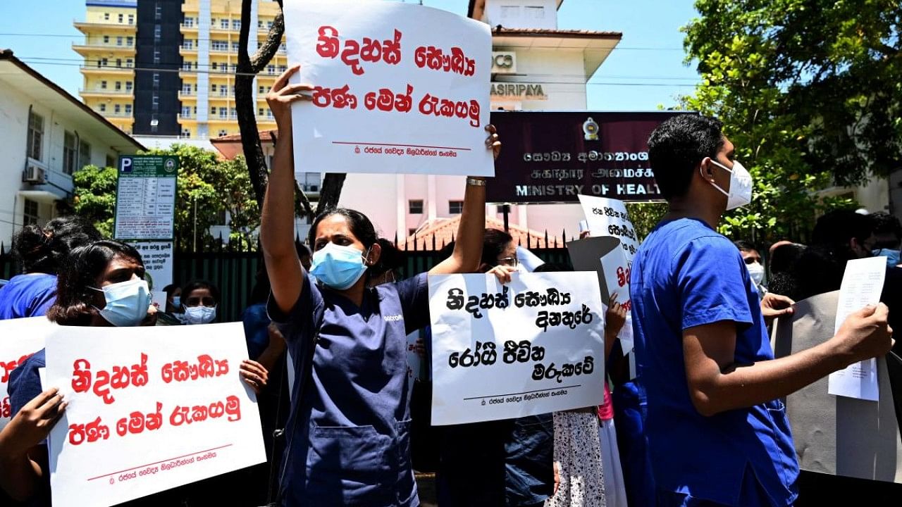 Members of the Government Medical Officers' Association hold placards during a silent demonstration against Sri Lanka's deepening economic crisis in Colombo. Credit: AFP Photo