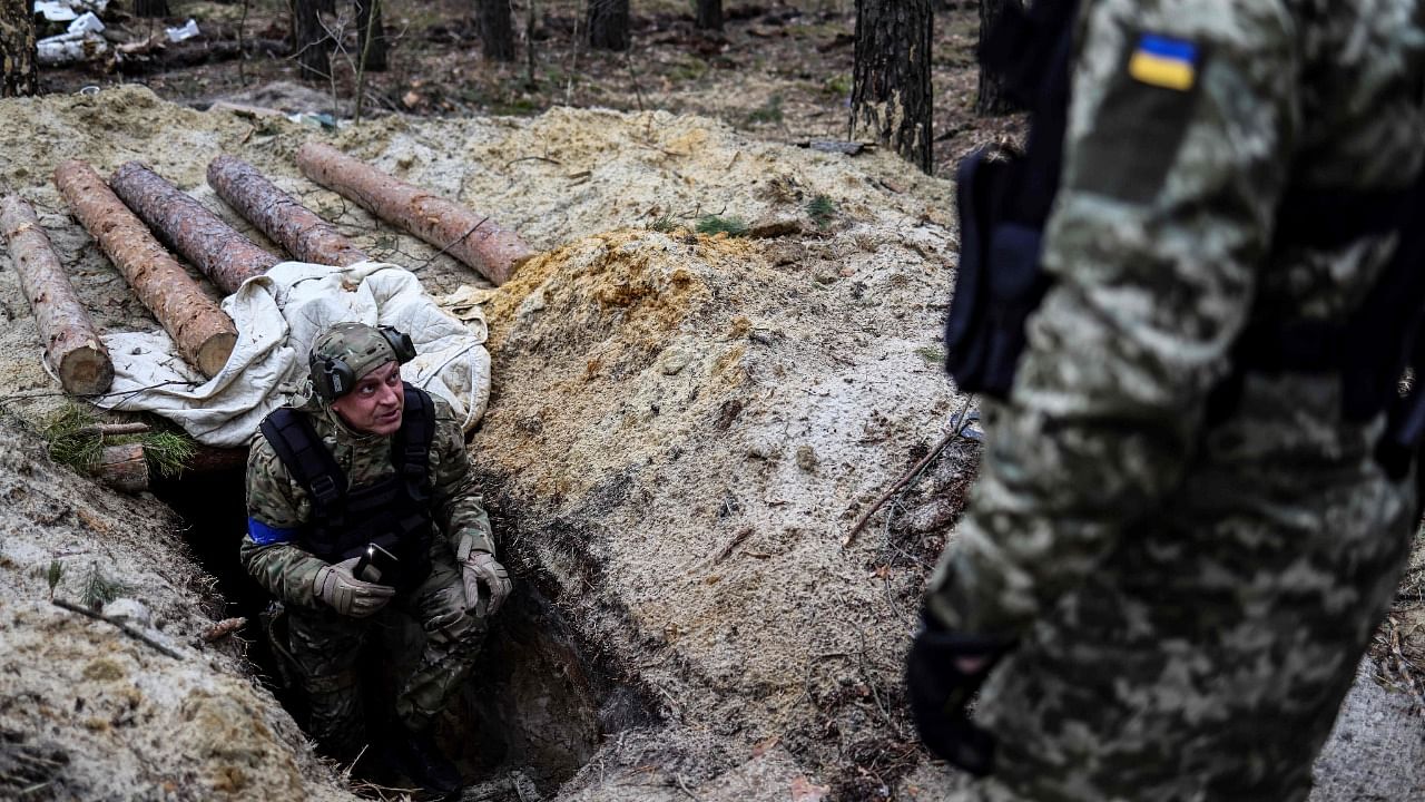 A member of Ukrainian army check a trencher in an empty Russian base camp near Buda-Babynetska, north of Kyiv. Credit: AFP Photo