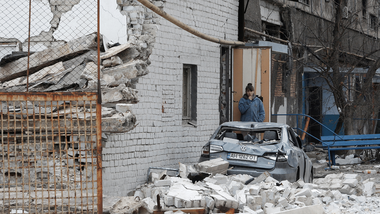A local resident stands near a damaged apartment building in Mariupol. Credit: Reuters Photo