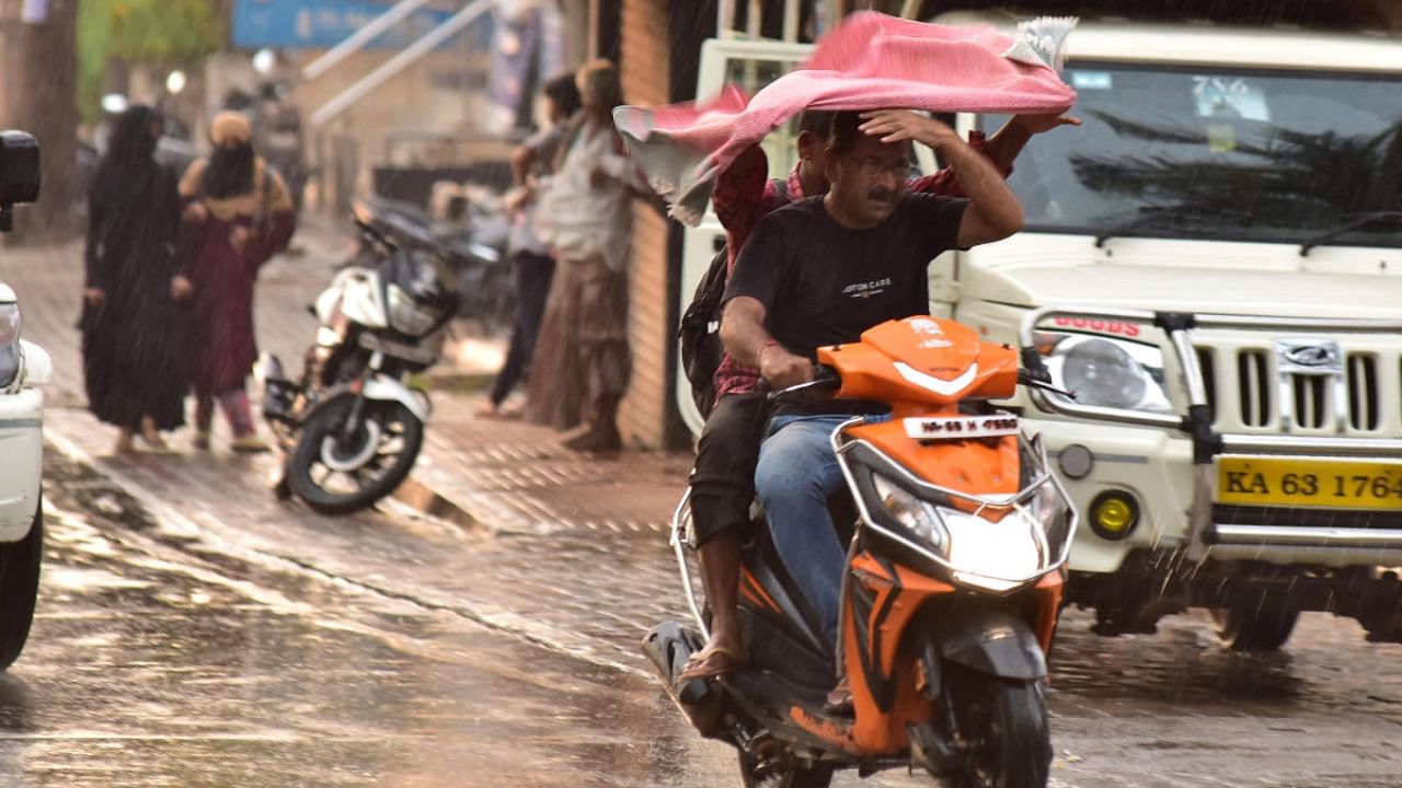 A motorist braves the rain in Hubballi on Thursday. Credit: DH photo