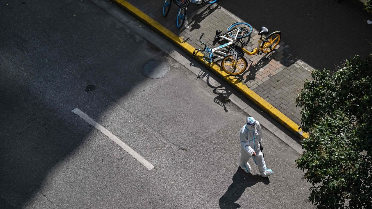 A policeman wearing personal protective equipment (PPE) walks on a street during a Covid-19 lockdown in the Jing'an district in Shanghai. Credit: AFP Photo