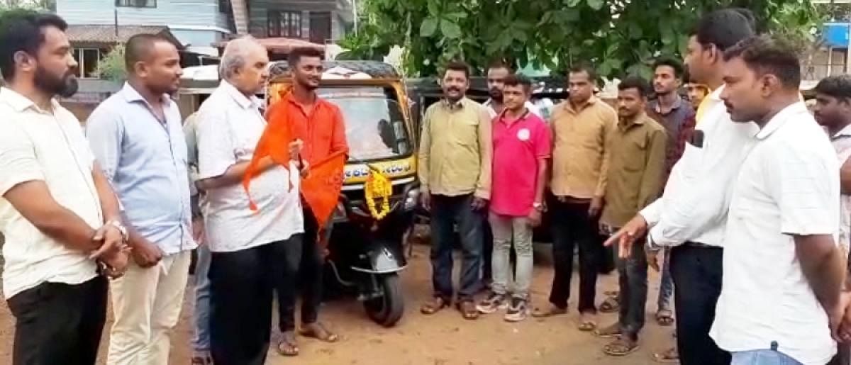 Members of Hindu Jagarana Vedike distribute Bhagwa Dhwaja to autorickshaw drivers in Puttur.