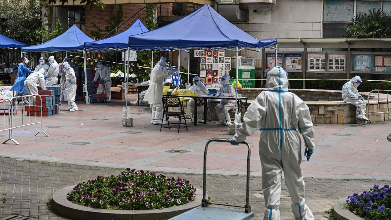 Health workers wearing personal protective equipment (PPE) are seen while waiting for residents for a test for the Covid-19 coronavirus in a compound during a Covid-19 lockdown in the Jing'an district in Shanghai. Credit: AFP Photo
