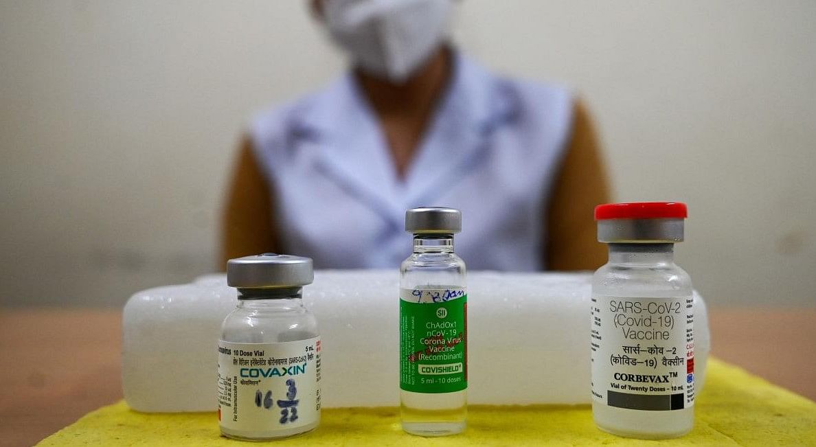 A health worker shows vials of Corbevax (R), Covishield (C) and Covaxin vaccines before a vaccination drive for people in the 12-14 age group at a hospital in New Delhi on March 16, 2022. Credit: Prakash Singh/ AFP