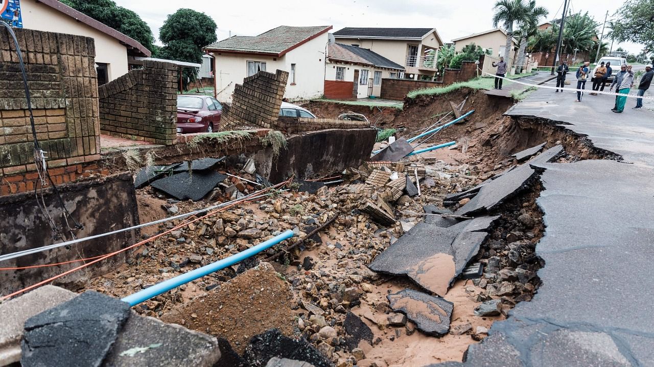 A general view of a severely damaged home and a crack in the road following heavy rains and winds in Durban. Credit: AFP Photo