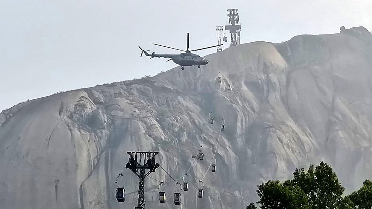 A helicopter hovers above during a rescue operation after the collision of two cable cars at Trikut Ropeway, in Deoghar, Tuesday, April 12, 2022. Credit: PTI Photo