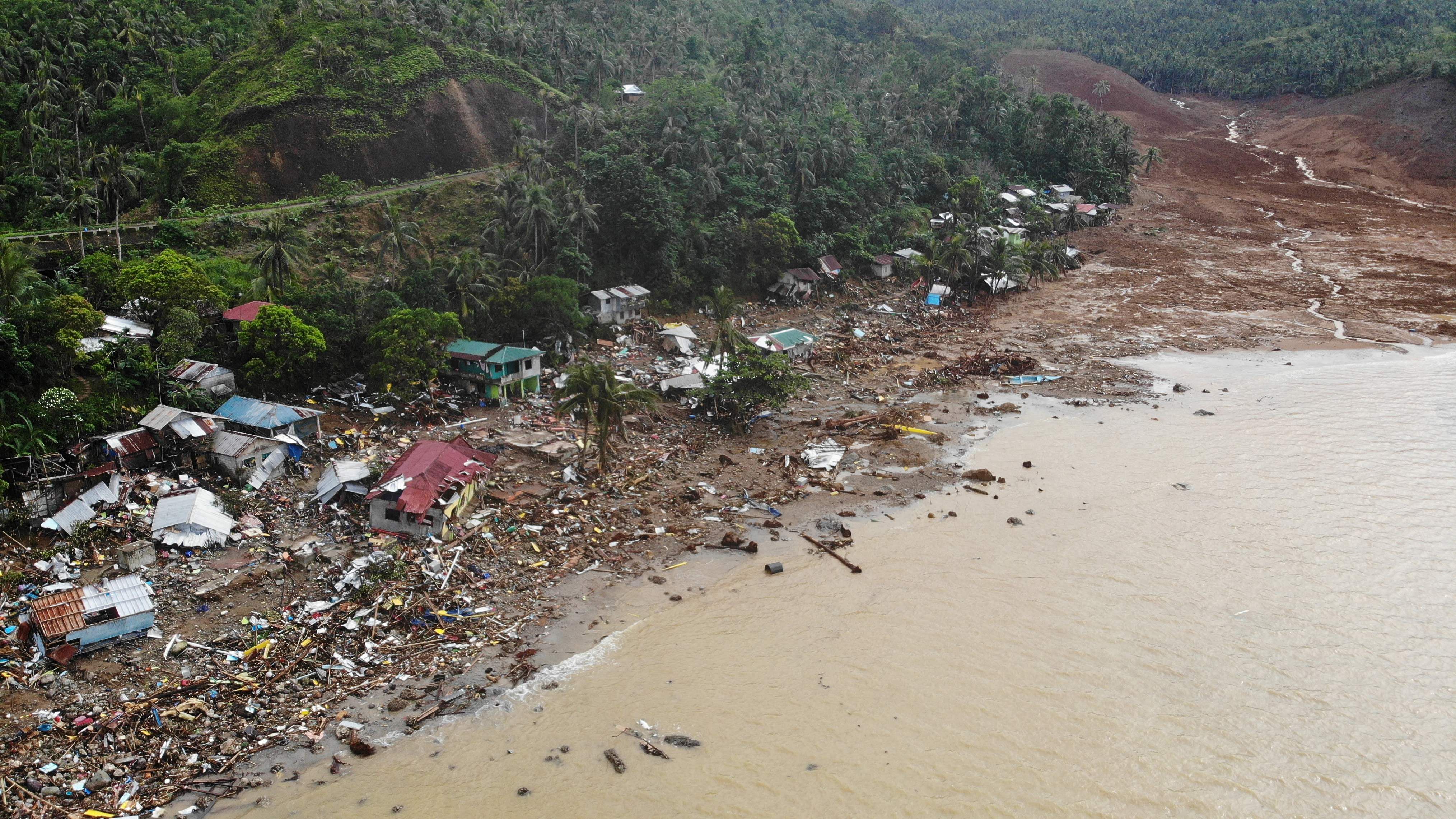 Aerial photographs and video from the local government showed collapsed slopes, burying coconut plantations and houses in dirt and mud. Credit: AFP Photo