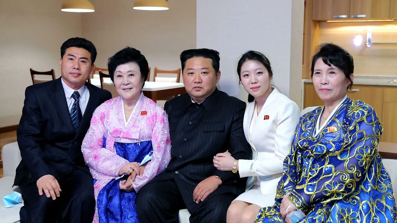 North Korean leader Kim Jong Un (C) posing with North Korean announcer Ri Chun Hee (2nd L) and her family. Credit: AFP Photo/KCNA via KNS