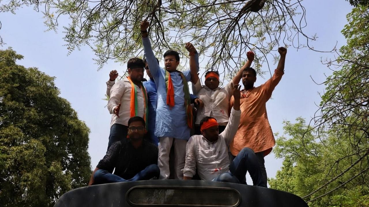 BJYM president Tejasvi Surya with supporters stage a protest against Delhi CM Arvind Kejriwal's statement over the film 'Kashmir Files' outside CM residence in New Delhi. Credit: IANS Photo