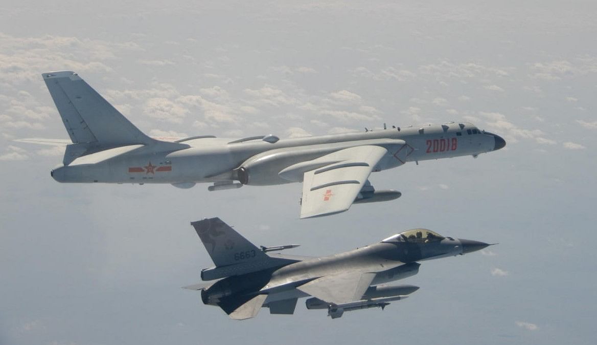 This file handout photo taken and released on February 10, 2020 by Taiwan's Defence Ministry shows a Taiwanese F-16 fighter jet flying next to a Chinese H-6 bomber (top) off the coast of Taiwan. Credit: AFP