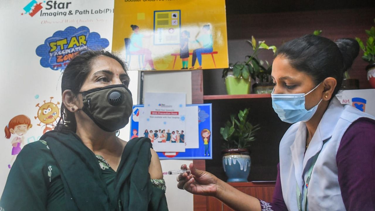 A health worker administers a booster dose of Covid-19 vaccine to a woman, in New Delhi. Credit: PTI Photo