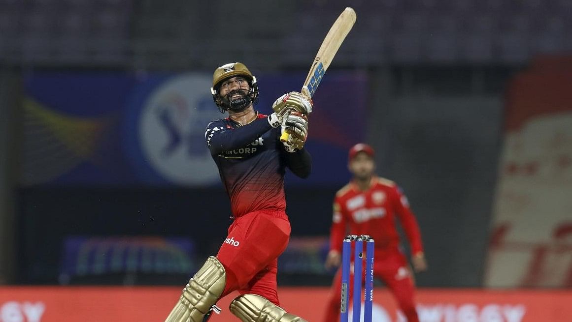 Dinesh Karthik of Royal Challengers Bangalore plays a shot during the 3rd T20 cricket match of the Indian Premier League 2022 (IPL season 15), between the Punjab Kings and the Royal Challengers Bangalore, at the DY Patil Stadium. Credit: PTI
