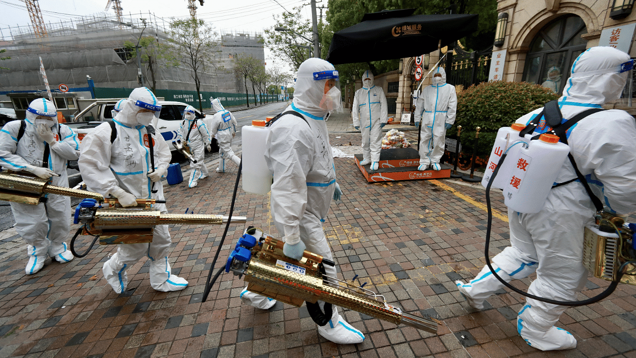 Volunteers in protective suits prepare to disinfect a residential compound in Huangpu district. Credit: Reuters Photo