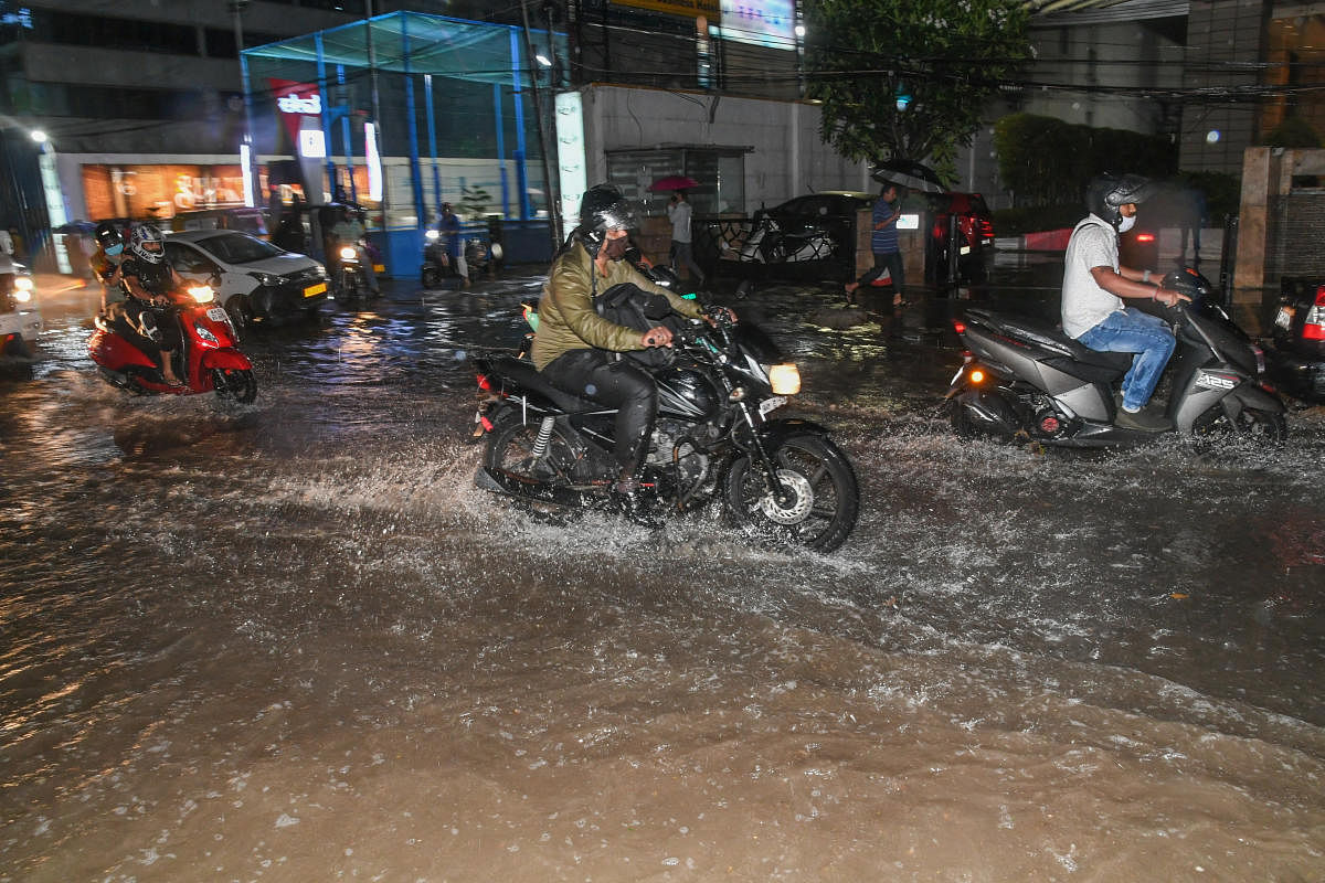 Motorcyclists make their way on a flooded Brigade Road as skies opened up towards evening in Bengaluru on Thursday. Credit: DH Photo