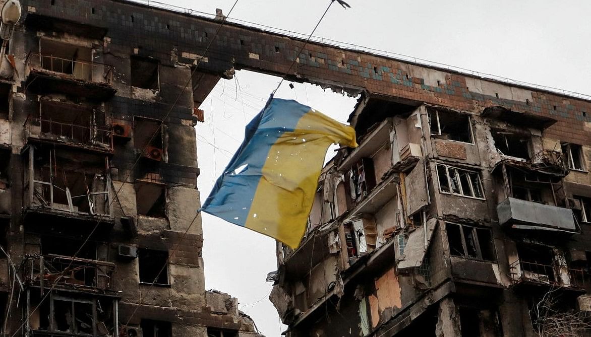 FILE PHOTO: A view shows a Ukrainian flag near a destroyed building in Mariupol. Credit: Reuters