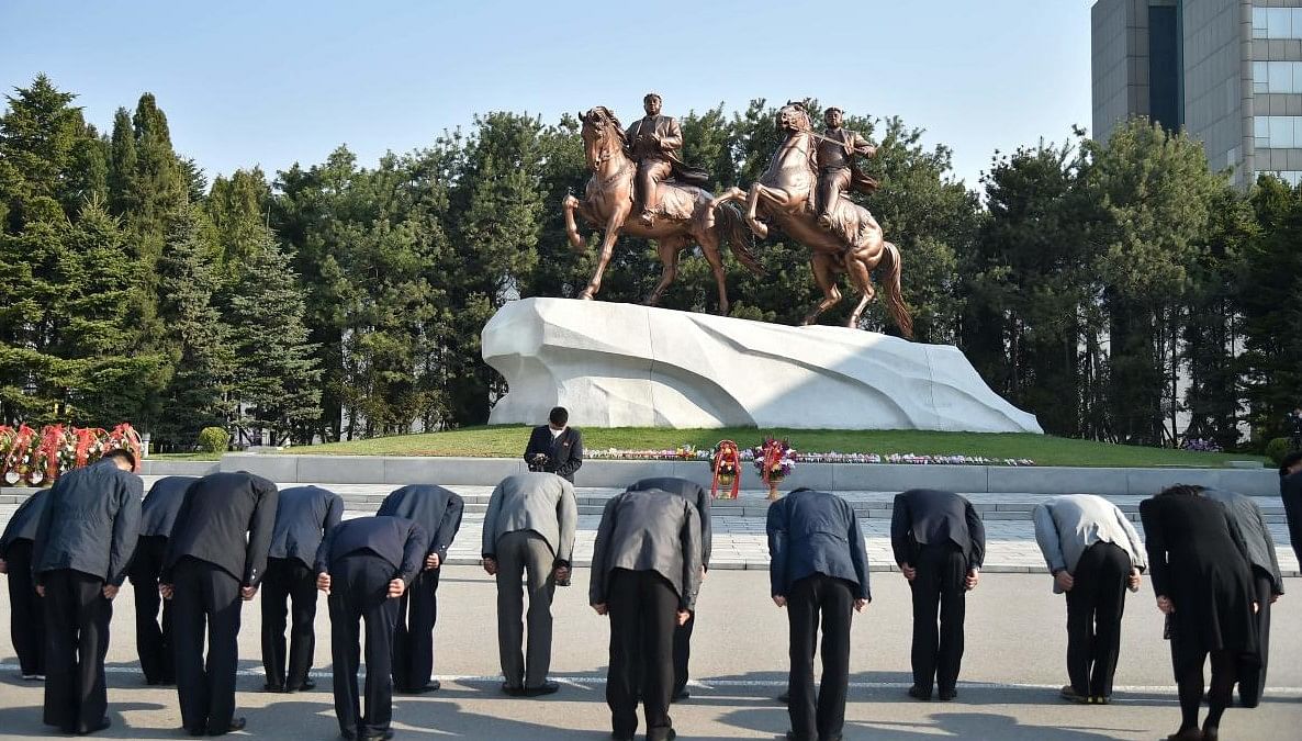 People bow before the statues of late North Korean leaders Kim Il Sung and Kim Jong Il at the Mansudae Art Studio, as part of celebrations marking the 110th anniversary of the birth of Kim Il Sung, known as the "Day of the Sun", in Pyongyang on April 15, 2022. (Photo Credit: KIM Won Jin / AFP)