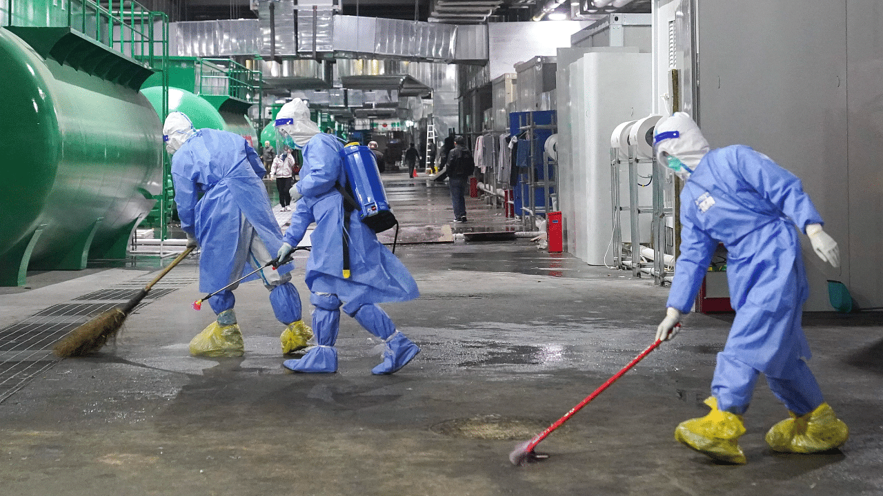 Workers clean and disinfect the floor of a makeshift hospital at the National Exhibition and Convention Center in Shanghai. Credit: AP Photo