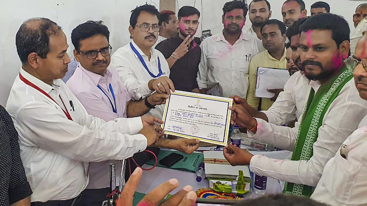 RJD candidate Amar Paswan receives the 'Certificate of Election' after winning the Bochahan assembly constituency bye-elections, in Muzaffarpur district. Credit: PTI Photo