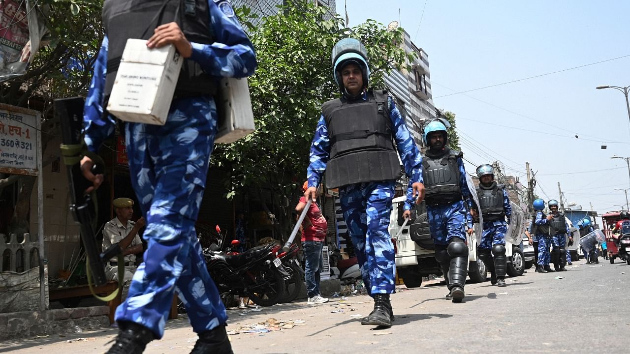 Rapid Action Force (RAF) personnel patrol along a street in Jahangirpuri area in New Delhi. Credit: AFP Photo