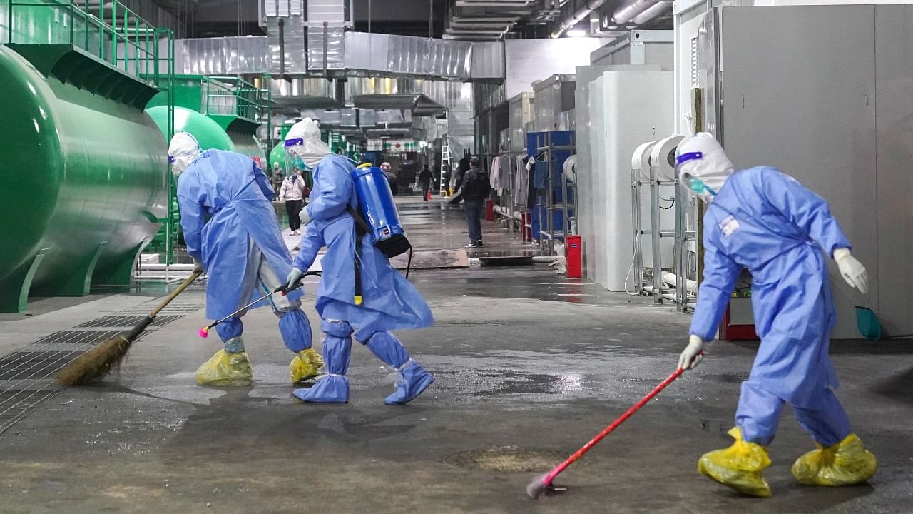 Workers clean a government-run quarantine facility at the National Exhibition and Convention Center in Shanghai. Credit: AP/PTI Photo