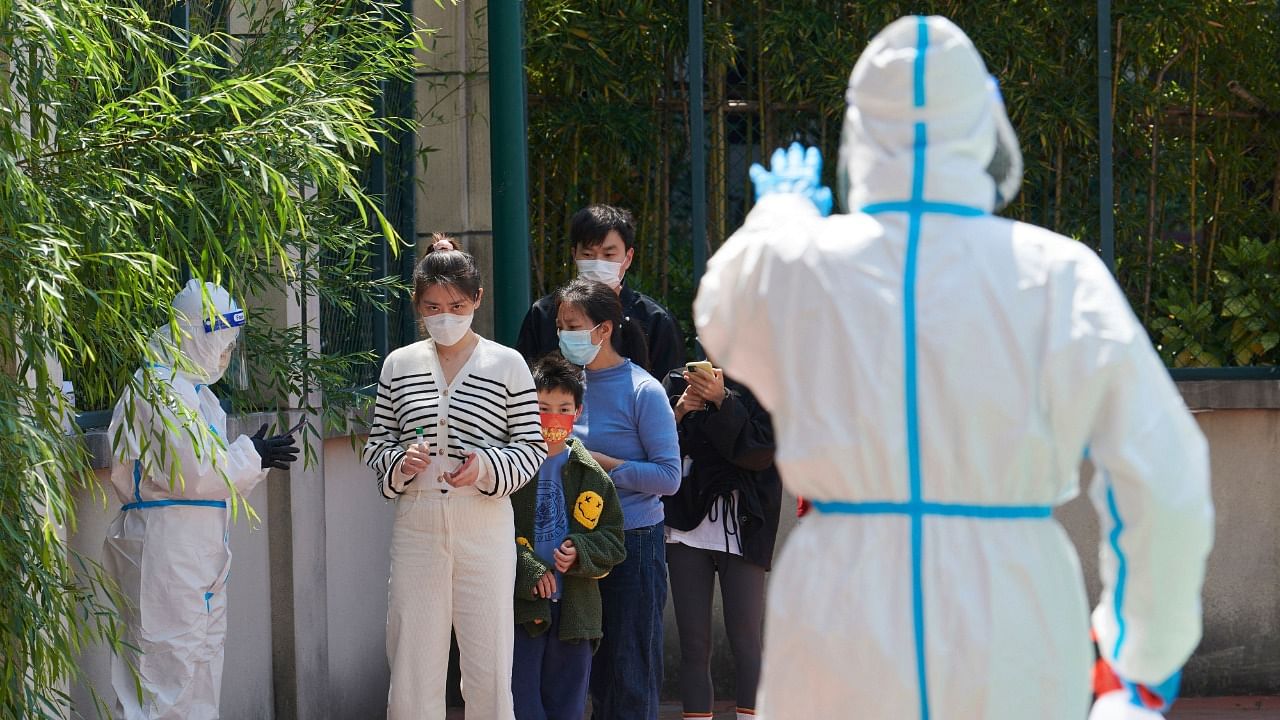 Community volunteers wearing personal protective equipment guide residents queuing to get tested for the Covid-19 coronavirus. Credit: AFP Photo