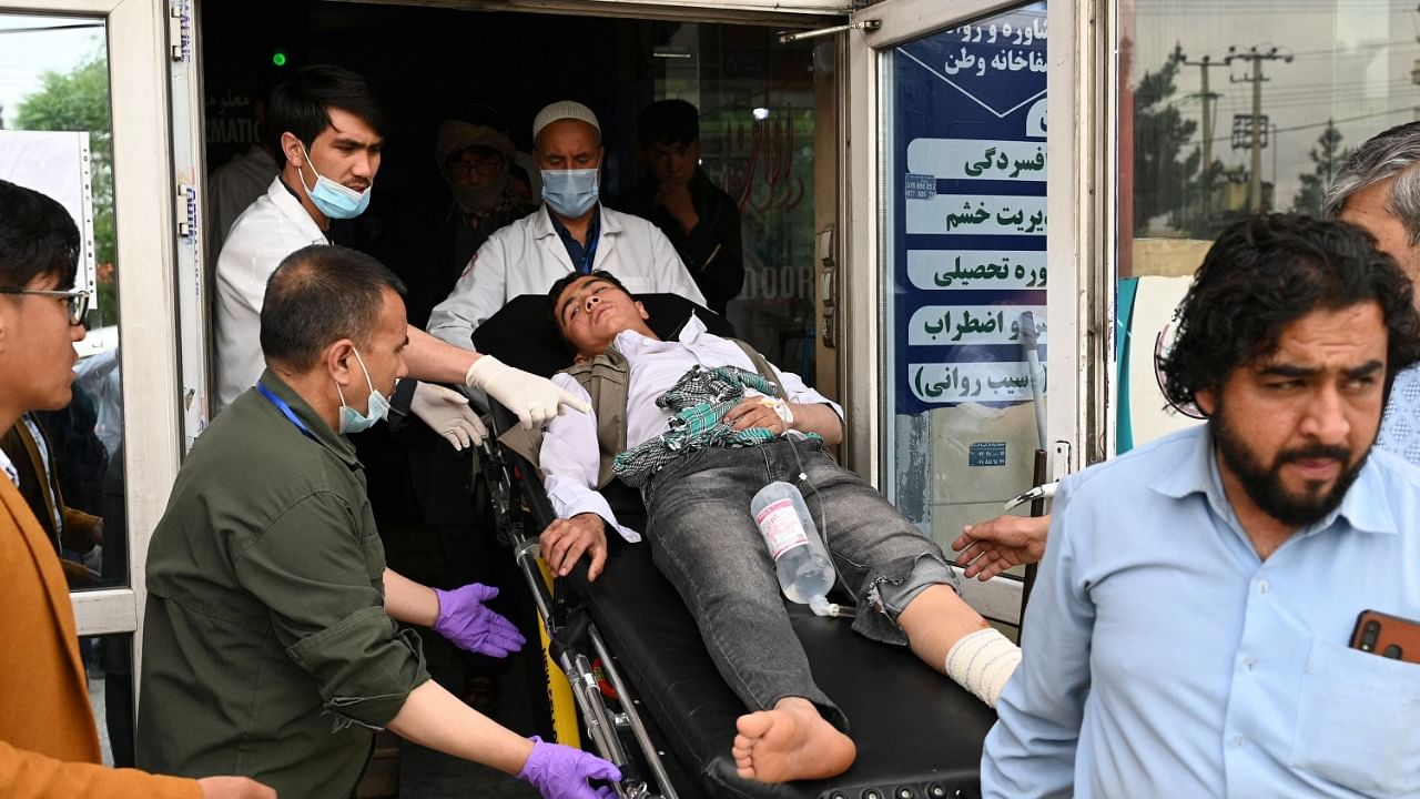 Medical staff move a wounded youth on a stretcher inside a hospital after three blasts rocked a boys' school in a Shiite Hazara neighbourhood. Credit: AFP Photo