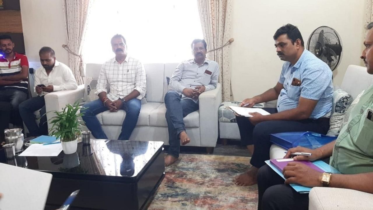 Hindalga Gram Panchayat President Nagesh Mannolkar (third from right) being subjected to inquiry by Udupi police in connection with death case of contractor Santosh Patil at Hindalga in Belagavi taluk on Tuesday. Credit: Special arrangement