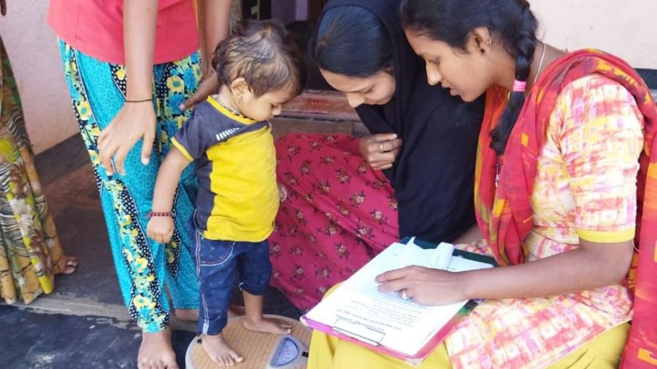 A Jagruti volunteer weighs a child to check for malnourishment. Credit: Special arrangement