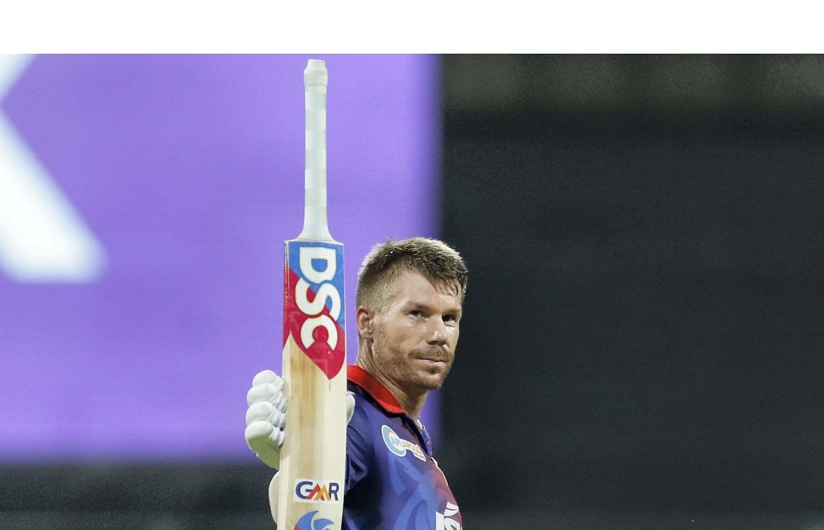 David Warner of Delhi Capitals raises his bat after scoring a fifty during the Indian Premier League 2022 cricket match between Delhi Capitals and Royal Challengers Bangalore. Credit: PTI