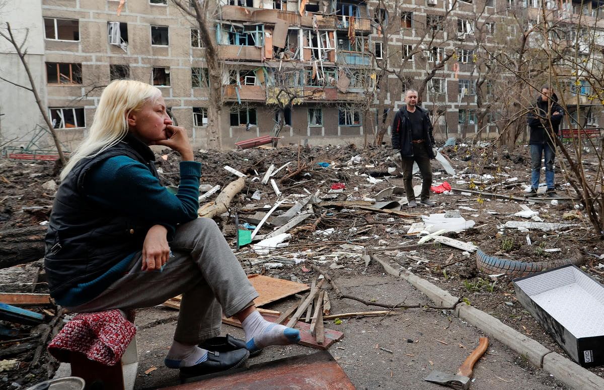 People gather in a courtyard outside a damaged block of flats in Mariupol. Credit: Reuters Photo