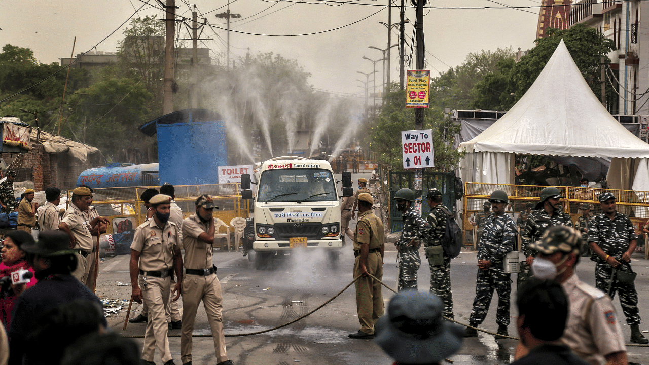 Water being sprayed in a locality a day after an anti-encroachment drive, in the violence-affected Jahangirpuri area, in New Delhi. Credit: PTI Photo