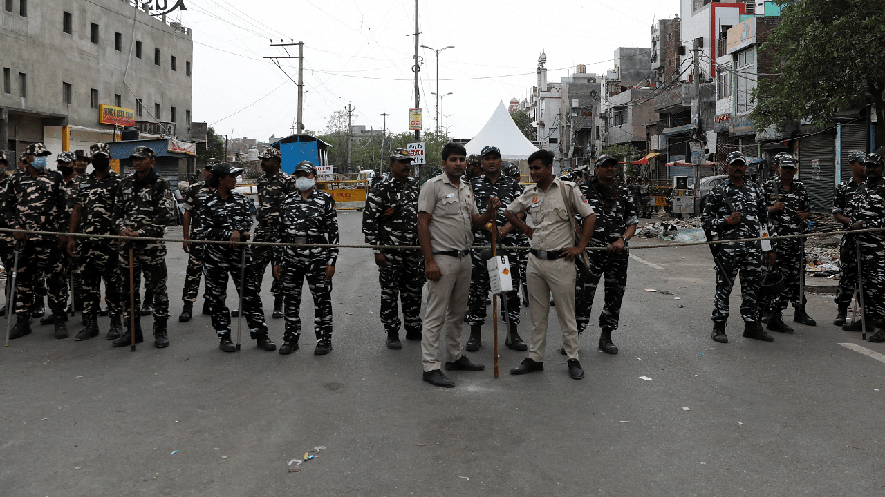 Police and paramilitary forces stand guard near the barricades put up after Wednesday's demolition of illegal encroachments, in Jahangirpuri. Credit: Reuters Photo