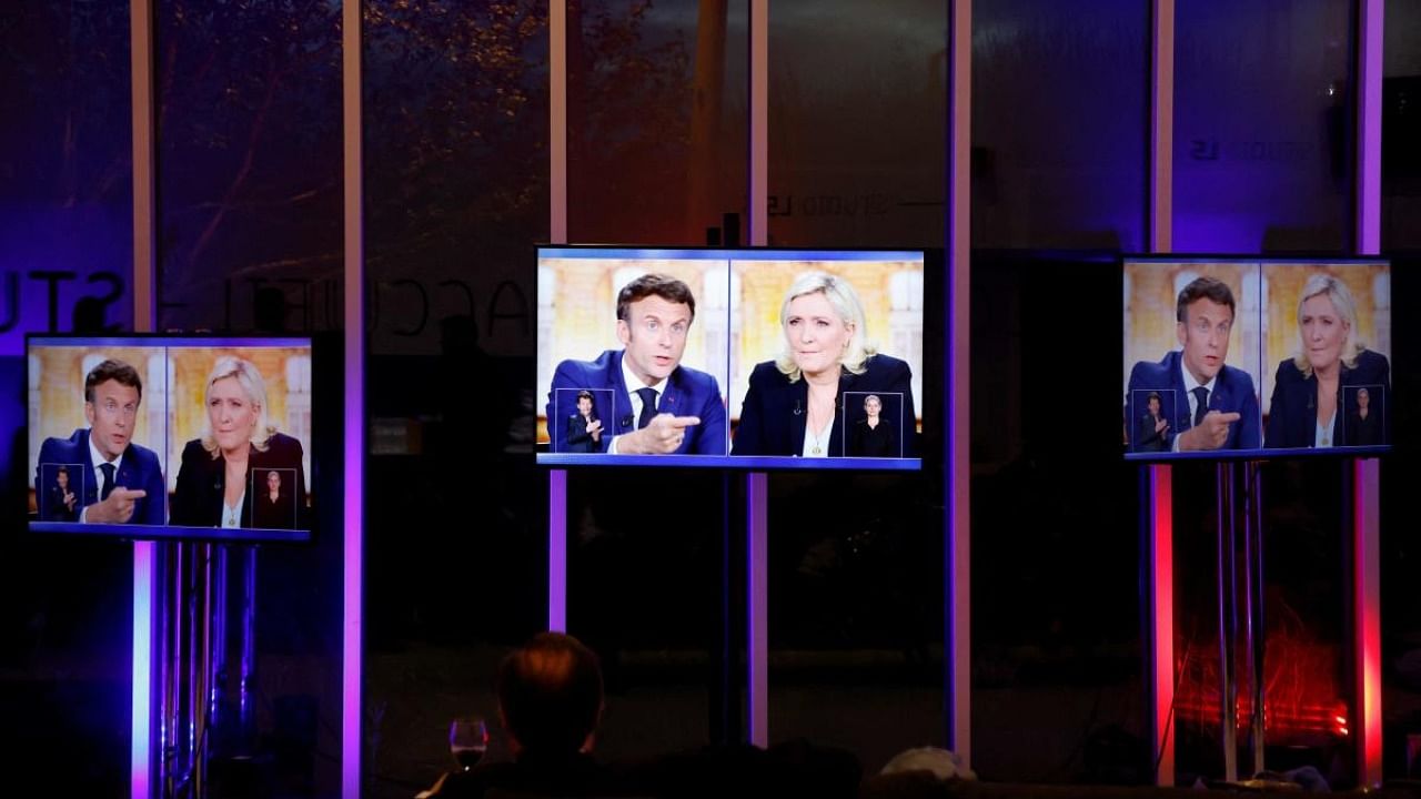 A picture shows screens displaying a live televised between French President and La Republique en Marche (LREM) party candidate for re-election Emmanuel Macron (L) and French far-right party Rassemblement National (RN) presidential candidate Marine Le Pen (R). Credit: AFP Photo