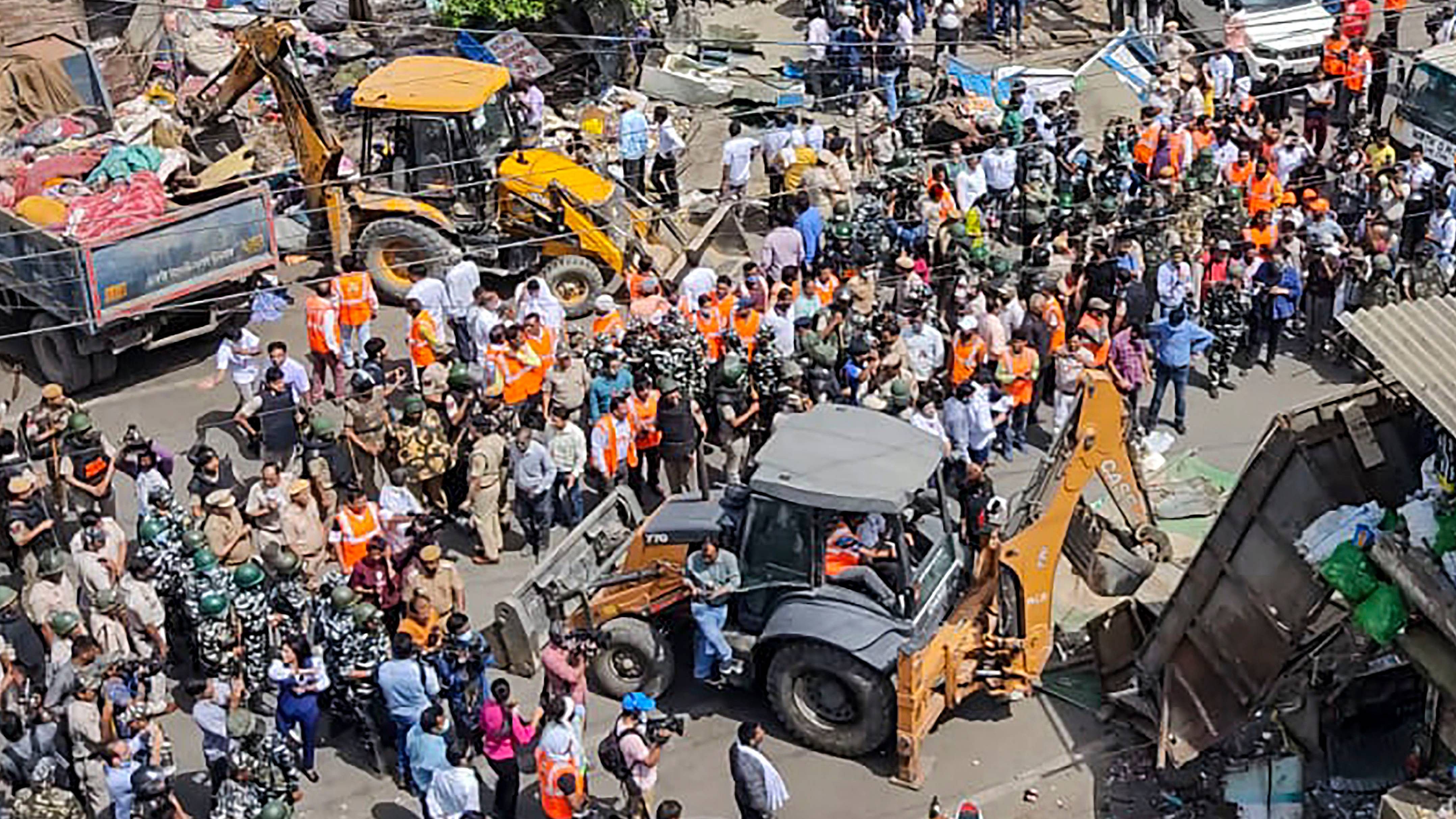Bulldozers being used to remove illegal structures during a joint anti-encroachment drive by NDMC, PWD, local bodies and the police, in the violence-hit Jahangirpuri area. Credit: PTI Photo