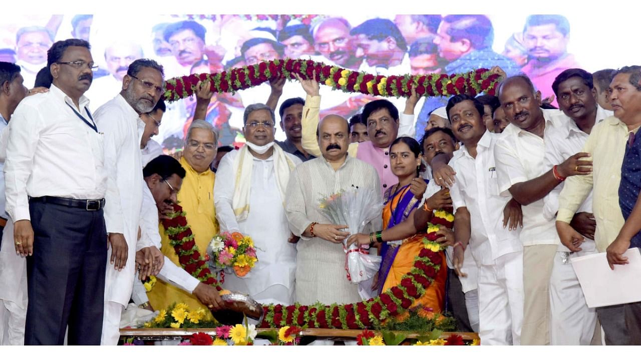 Farmers garland CM Basavaraj Bommai, Leader of the Opposition in the Assembly Siddaramaiah, Water Resources Minister Govind Karjol, Industries Minister Murugesh Nirani and Public Works Minister C C Patil at a function to lay foundation stones for lift irrigation projects  at Ugalawat in Badami taluk of Bagalkot district on Friday. Credit: DH Photo