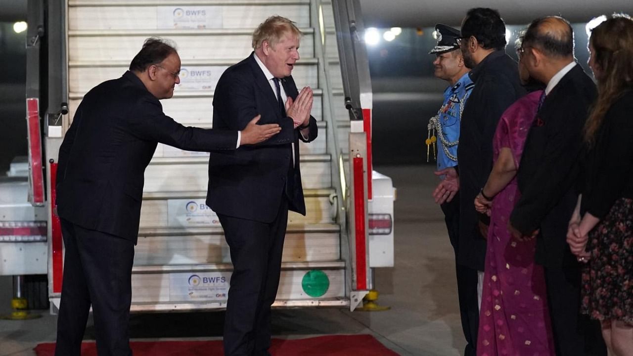 Britain's Prime Minister Boris Johnson (C) disembarks the plane having arrived at Indira Gandhi International Airport in New Delhi on April 21, 2022, after a day of engagements in Gujarat. Credit: AFP Photo