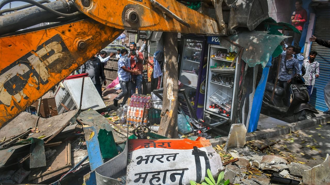 A bulldozer being used to demolish illegal structures during a joint anti-encroachment drive by NDMC, PWD, local bodies and the police, in the violence-hit Jahangirpuri area. Credit: PTI Photo