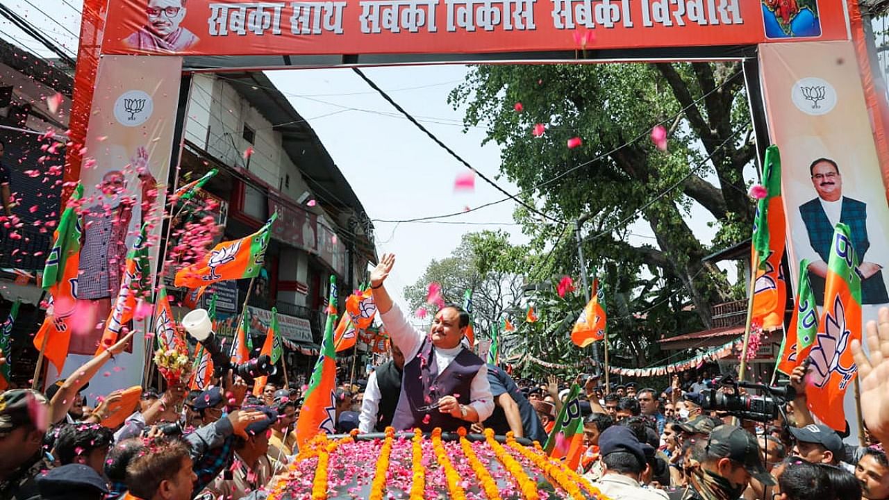 BJP National President JP Nadda waves at his supporters during a roadshow, at Nagrota Bagwan in Kangra. Credit: PTI Photo