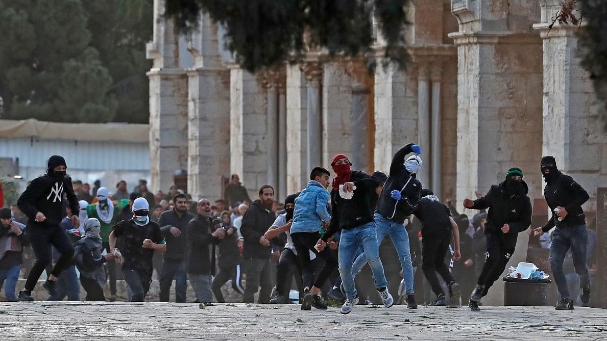 Palestinian demonstrators throw stones at Israeli police at Jerusalem's Al-Aqsa mosque compound. Credit: AFP