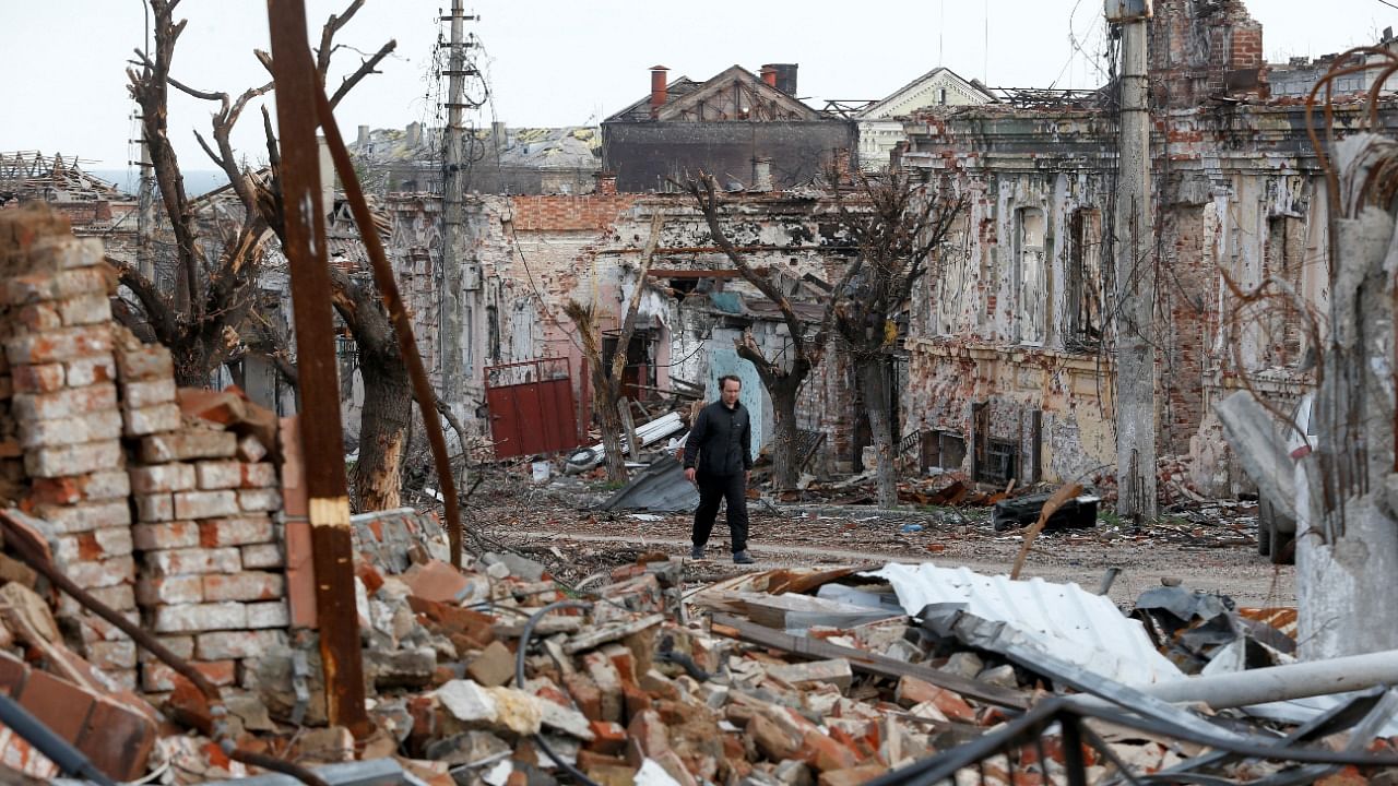 A man walks near damaged buildings in the course of Ukraine-Russia conflict in the southern port city of Mariupol. Credit: Reuters photo