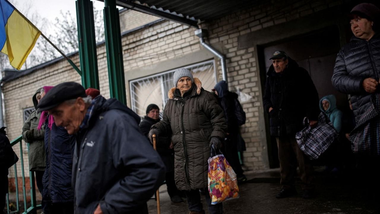 Locals gather for a food distribution at the community centre of the village of Mala Rohan, amid Russia's invasion of Ukraine, in Kharkiv region. Credit: Reuters photo