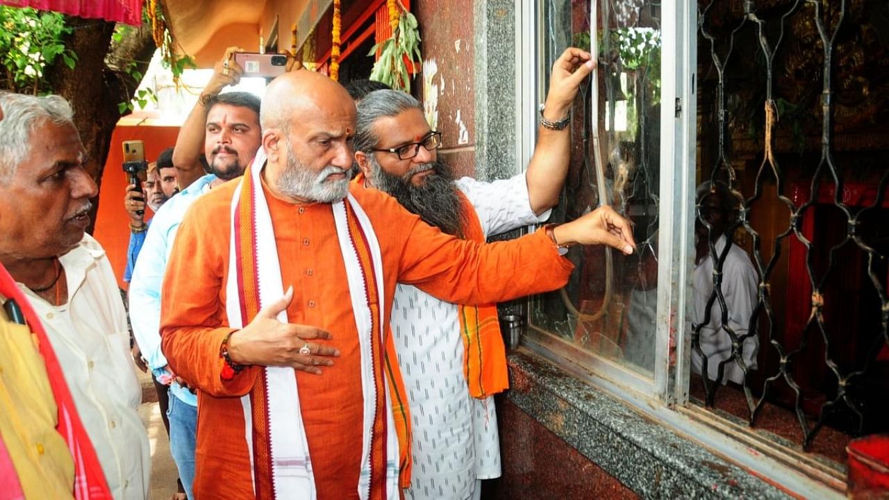 Pramod Muthalik observes window glass damaged due to stone pelting, at Diddi Hanumanth Temple in Old Hubballi on Friday. Credit: DH Photo