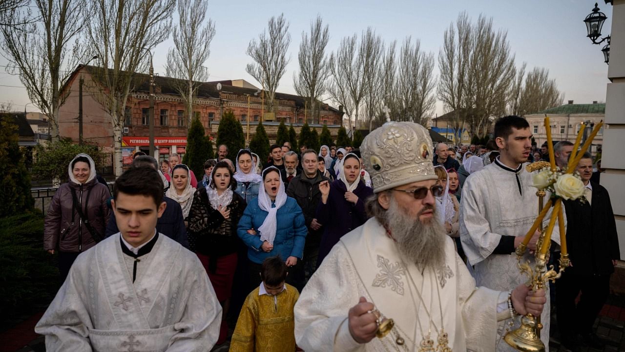 An orthodox priest leads a procession as people gather to mark orthodox Easter day. Credit: AFP Photo