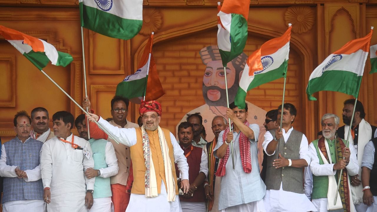 Union Home Minister Amit Shah with others waves the national flag during Veer Kunwar Singh Vijayotsav at Jagdishpur, Bihar. Credit: PTI Photo