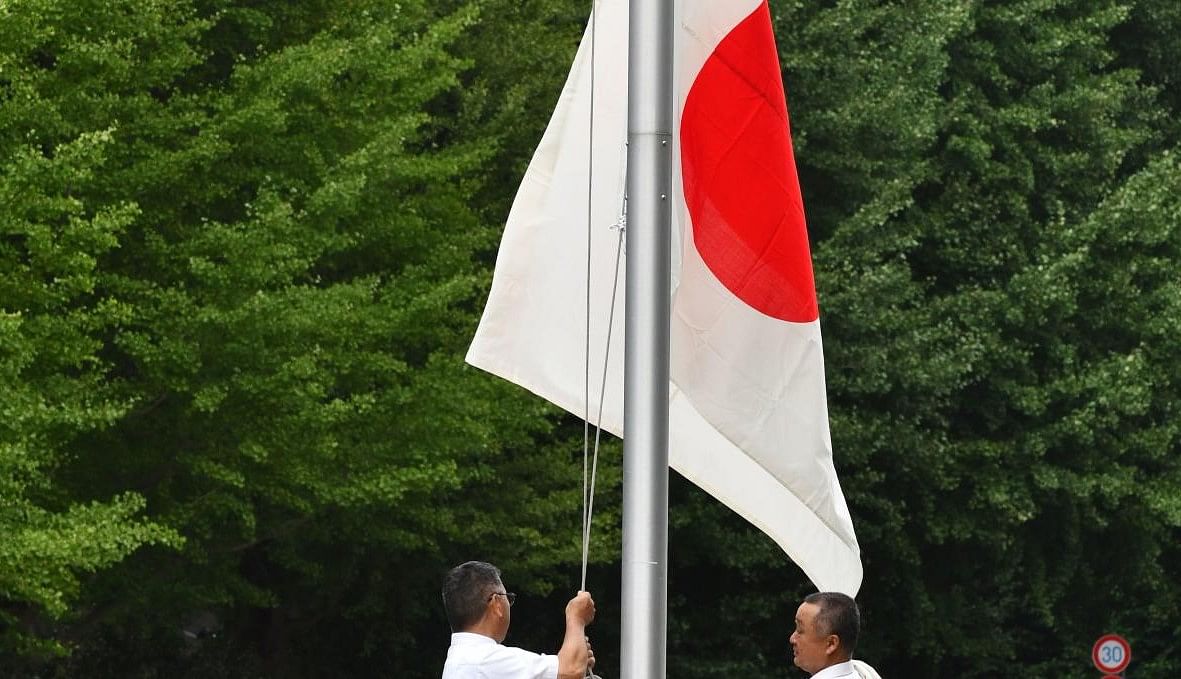 The Japanese national flag is hoisted at Tokyo's Nippon Budokan for a memorial ceremony for Japan's war dead on August 15, 2019, as the country marks the 74th anniversary of its surrender in World War II. (Photo by Kazuhiro NOGI / AFP)