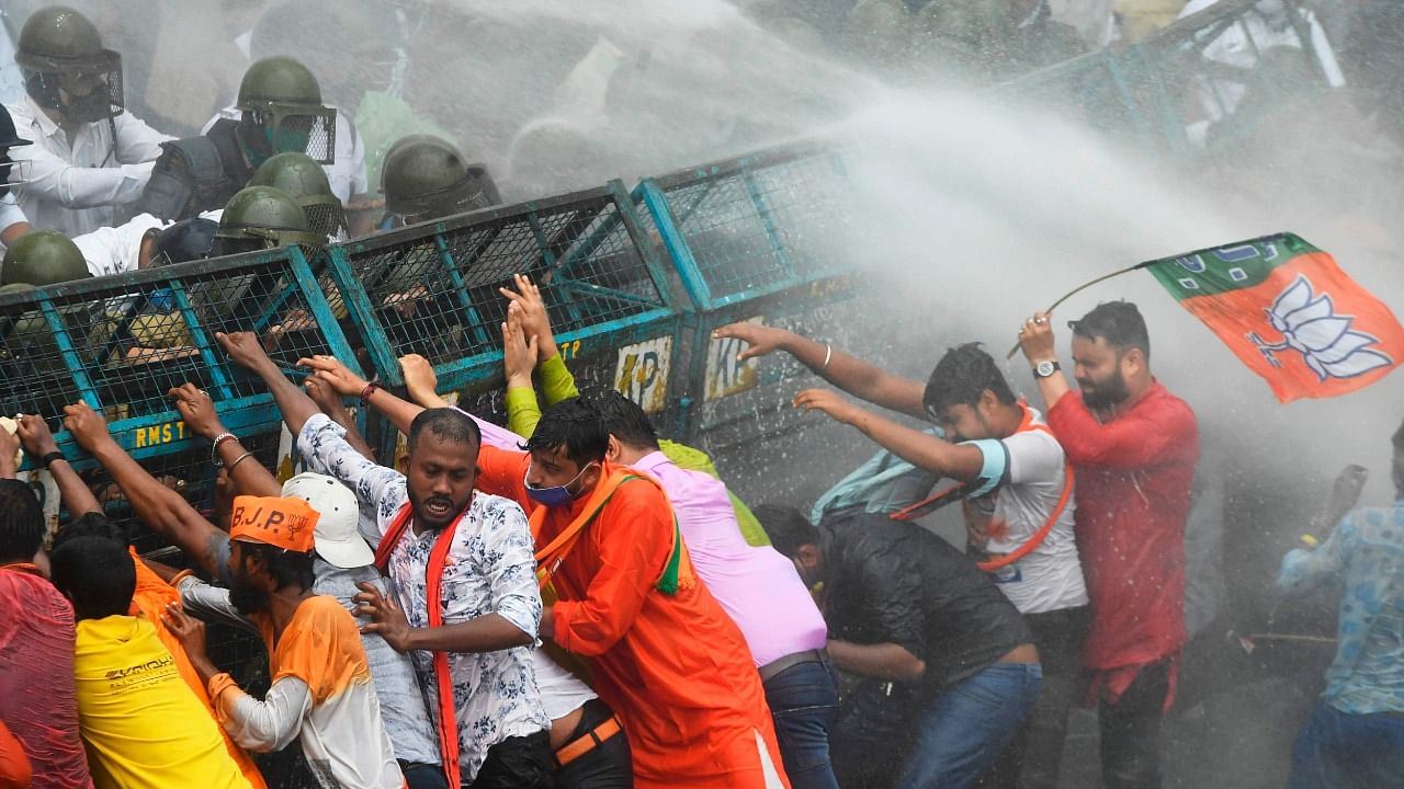 Activists of the Bhartiya Janata Party (BJP) try to breakthrough a police barricade as police use a water canon. Credit: AFP Photo