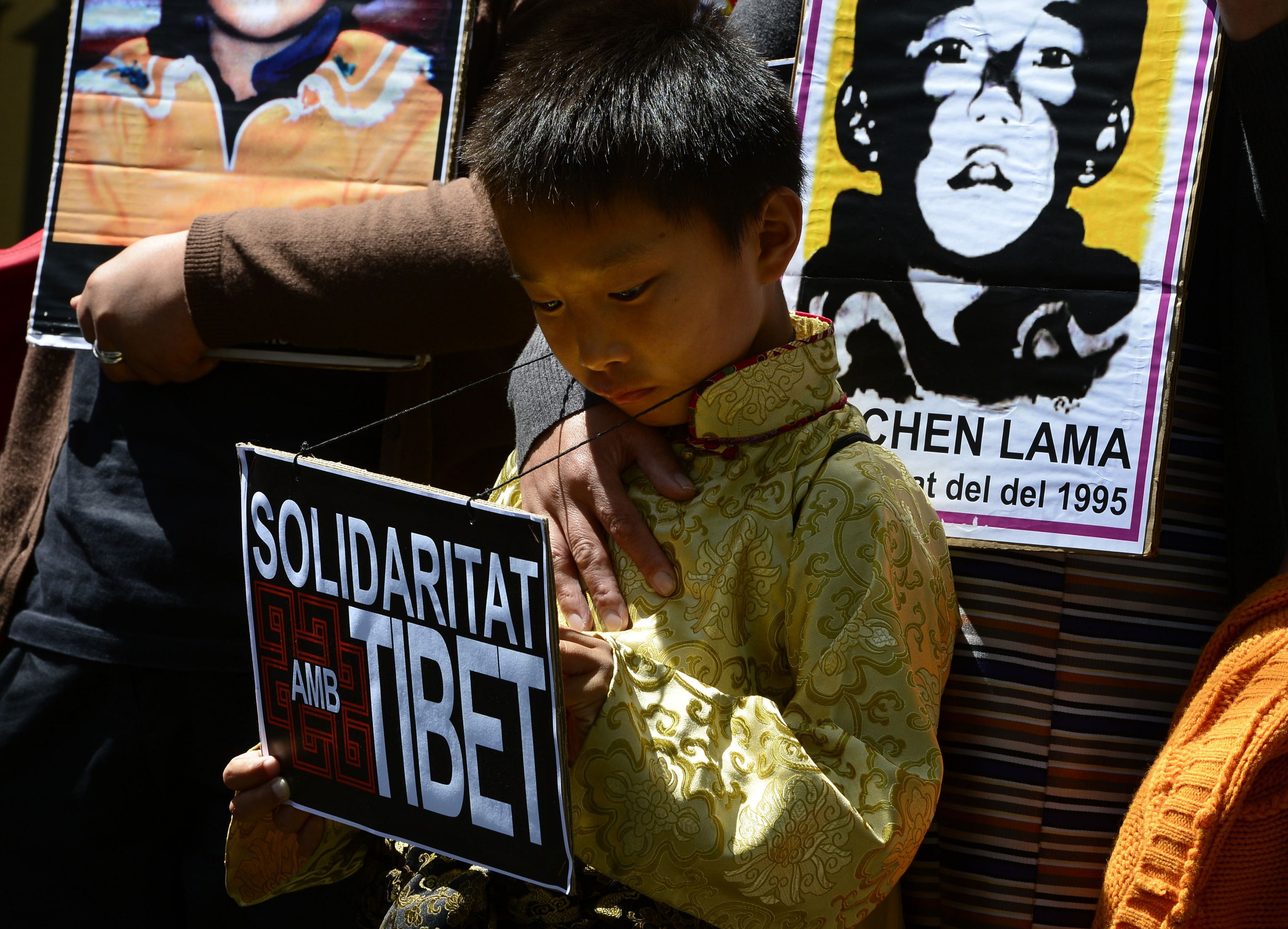 Pro-Tibetan protestors hold picures of Gendun Cheokyi Nyima (The Panchen Lama) during a demonstration outside the Chinese consulate in Barcelona in Barcelona. Credit: AFP Photo