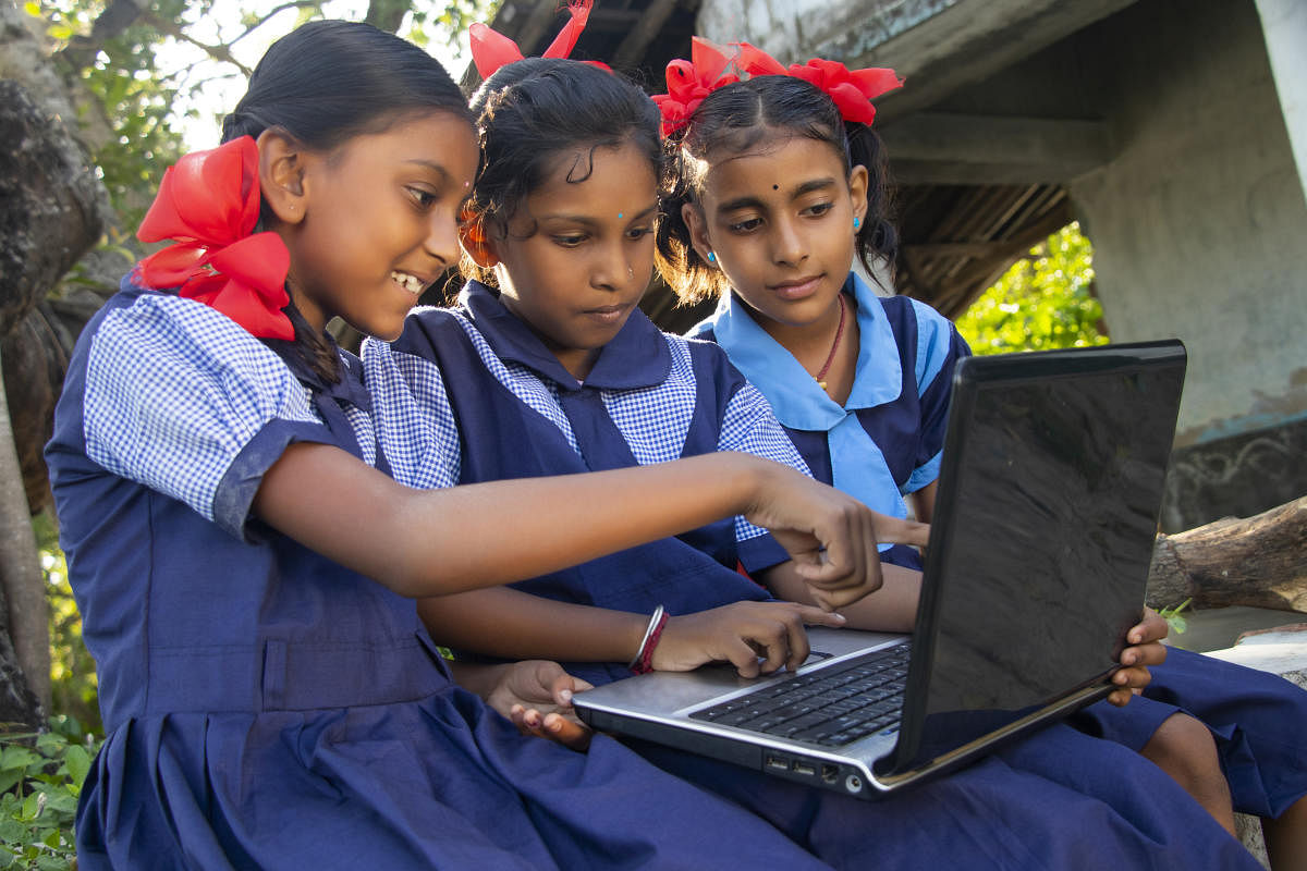 indian village government school girls operating laptop computer system at rural area in indiaIndian village government school girls operating laptop computer system