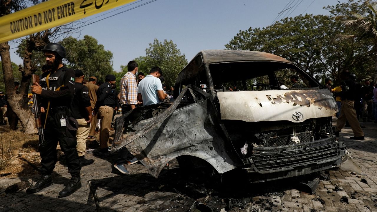 Police officers and crime scene unit gather near a passenger van, after a blast at the entrance of the Confucius Institute, University of Karachi, Pakistan. Credit: Reuters Photo