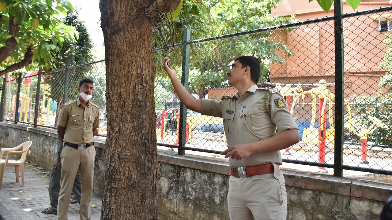Officials examine the spot in Sanjaynagar where a man was electrocuted on Monday night. Credit: DH Photo/B K Janardhan